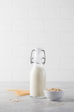 Alternatif sebze sütü, arka planda hafif bir şişedeki yulaf gevreğinden. Vejetaryen sütü.