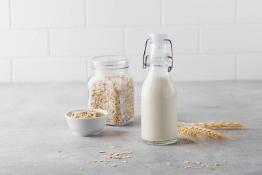 Alternatif sebze sütü, arka planda hafif bir şişedeki yulaf gevreğinden. Vejetaryen sütü.