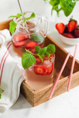 Sürahi ve bardakta ev yapımı taze çilekli limonata.