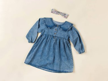 Bej arka planda bebek kot elbisesi. Çocuk modası konsepti. Düz yatıyordu.