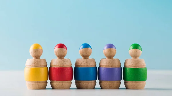 Educational wooden toy. Colored dwarfs in barrels on a blue background. Early childhood development.