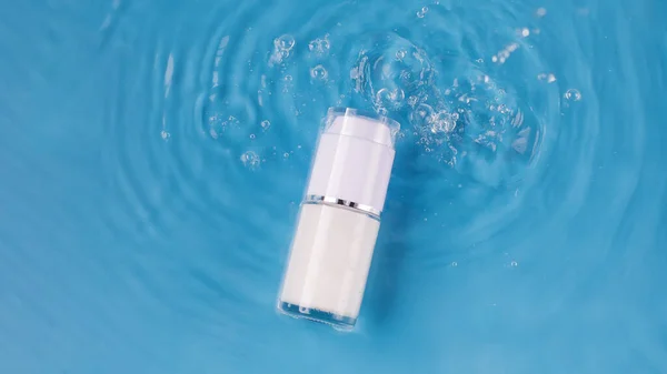 Mockup of a jar of moisturizing cream in water with drops and a blue background. Cosmetic product for everyday makeup. Luxury cosmetics presentation