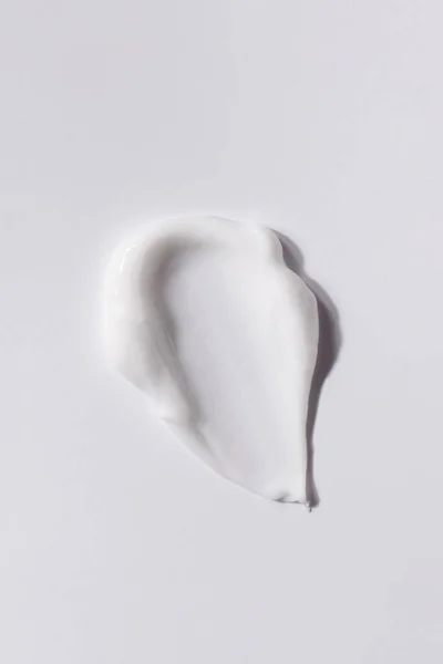 Beyaz arka planda beyaz cilt kremi lekesi. Kozmetik doku. Cilt bakımı kavramı.