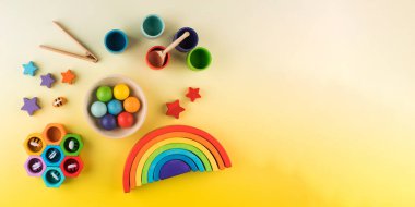  Sarı arka planda Montessori metoduna göre çevre dostu ahşap eğitim oyuncakları. kopyalama alanı. Erken çocukluk gelişimi kavramı.