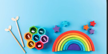Mavi arka planda, okul öncesi çocuklar için Montessori metoduna göre çevre dostu ahşap eğitim oyuncakları. Tahta gökkuşağı ve diğer oyuncaklar. Pankart