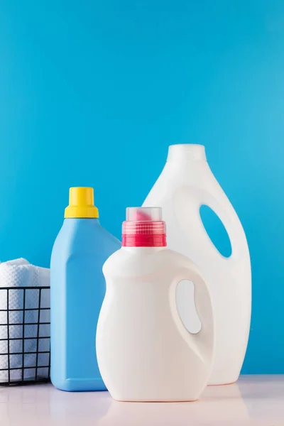 Different bottles with washing gel on a blue background. The concept of laundry, washing, household chemicals. Place for a logo.