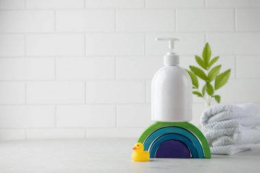  Ahşap bir gökkuşağında bebek kozmetiği ve arka planda yeşil bir bitki olan beyaz plastik bir şeker kutusu. Çocuk hijyeni kavramı..