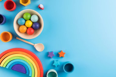  Mavi arka plandaki Montessori metoduna göre çevre dostu ahşap eğitim oyuncakları. kopyalama alanı. Erken çocukluk gelişimi kavramı.