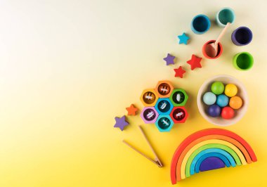  Sarı arka planda Montessori metoduna göre çevre dostu ahşap eğitim oyuncakları. kopyalama alanı. Erken çocukluk gelişimi kavramı.