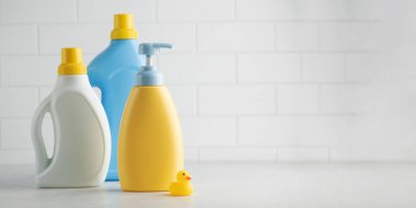 Bebek sabunu ve banyoda sarı ördekli çamaşır jeli. Çocuklar için organik kozmetik ve deterjan. Çocuk hijyeni..