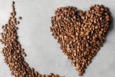 Gri arka planda kalp şeklinde kahve çekirdekleri. Kahve temalı. 