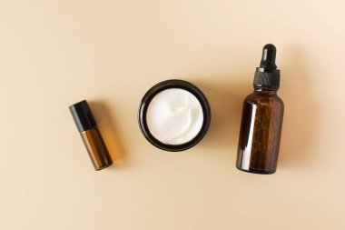 Kahverengi kavanozlar ve bej arka planda doğal bir kompozisyon. Cilt bakımı. Üst görünüm