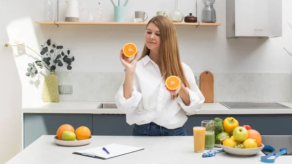 Langhaarige Frau Hält Geschnittene Orange Neben Einem Tisch Mit Früchten — Stockfoto