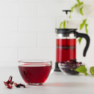 Hafif arka planda şeffaf bir fincanda amber yaprağından yapılmış bitki çayı..