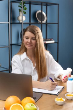 Diyetisyen uzman ofisteki vitaminleri gösteren video bağlantısıyla hastayla iletişim kuruyor. İyilik için en iyi diyeti seçiyorum. Sağlık hizmetleri