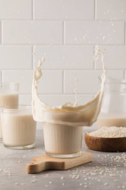 Hafif arka planda sebzeli pirinç sütü olan bir bardağa su sıçrat. Sağlıklı gıda konsepti. 