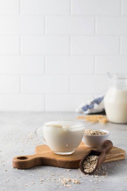 Bitkisel yulaf sütüyle bardaktan damlıyor. Vejetaryen sütü. Boşluğu kopyala. 