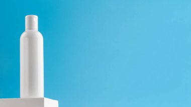  Mavi arka plandaki kaidede kozmetik ürünü olan boş bir şişe. Micellar su, yüz temizleme losyonu. Temizlik ve ferahlatıcı tedaviler. Pankart. Boşluğu kopyala