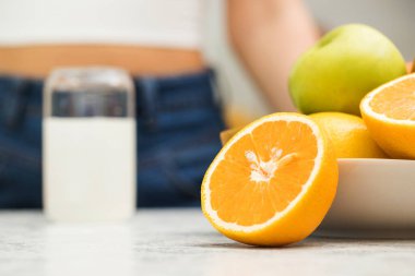 Mutfak masasında yarım portakal ve bir bardak sulandırılmış coşkulu vitamin. C vitamini, multivitaminler