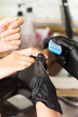  Manikürcü işi. Usta müşterileri bir çubuk yardımıyla çiviler, dosya. Güzellik endüstrisi.