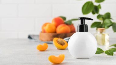  Kayısı çekirdeği özüyle birlikte kozmetik sıvı ürün içeren beyaz bir dağıtıcının maketi. Rutin vücut ve saç bakımı için kozmetik ürünler. Boşluğu kopyala