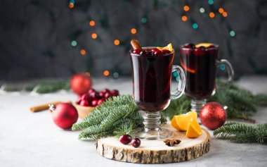 Baharatlar, portakal çiçekleri ve bir Noel ağacının dallarıyla çevrili sıcak şarap kadehleri.. 