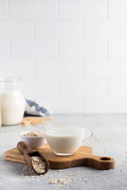 Masadaki fincanda yulaf ezmeli sebze sütü ve kasede yulaf ezmesi. Vejetaryen sütü. Sağlıklı yemek..