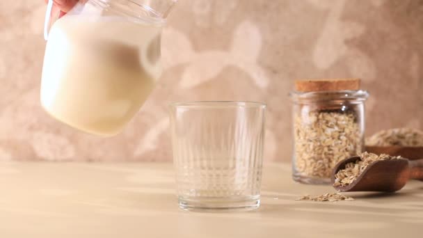 一个女人把燕麦牛奶倒进杯子里 替代牛奶 健康的生活方式 — 图库视频影像