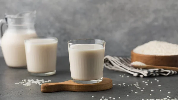 野菜の米ミルクと灰色の背景にジャグの眼鏡 ベジタリアンフード 乳糖フリーミルク 健康的なライフスタイル — ストック写真