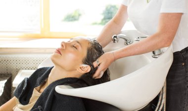 Kuaför müşterinin kafasını güzellik salonunun lavabosunda yıkar. Güzellik endüstrisi konsepti.
