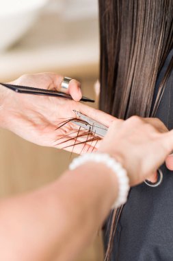 Kuaför müşterilerin bir kısmını düz saçlarıyla tutuyor ve kesiyor. Güzellik salonu konsepti, kuaförlük eğitimi..