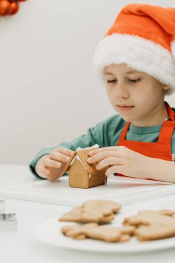 Noel arifesinde tatlı bir çocuk Noel Baba şapkasıyla mutfakta zencefilli ev yapar. Mutlu yıllar ve Noel. Kendi ellerinle bir hediye..