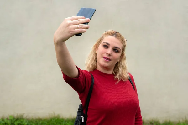Πορτρέτο μιας νεαρής ελκυστικής γυναίκας κάνοντας selfie φωτογραφία στο smartphone — Φωτογραφία Αρχείου