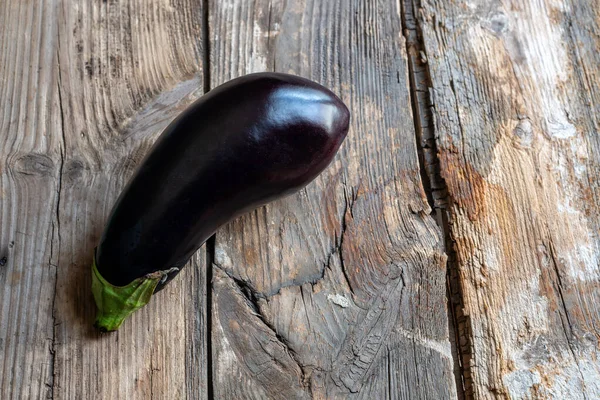 Eski ve aşınmış ahşap arka planda taze patlıcan..