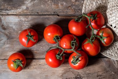 Eski ahşap bir masada bir grup domates.