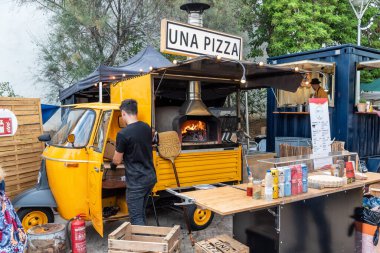 SİTGES, BARCELONA, İSPA - ECTOBER 08, 2022: Pizza yapmak için ahşap yakılmış fırın ile fast food hazırlamak için üç tekerli hafif ticari araç