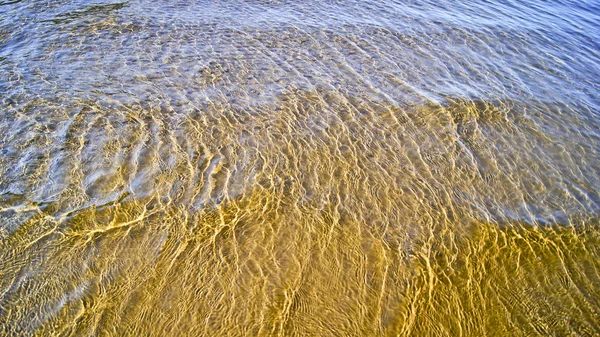 Ondas em uma praia de areia — Fotografia de Stock