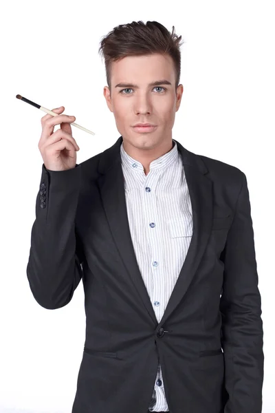 Stylish young handsome man in a suit with a brush. — Stock Photo, Image