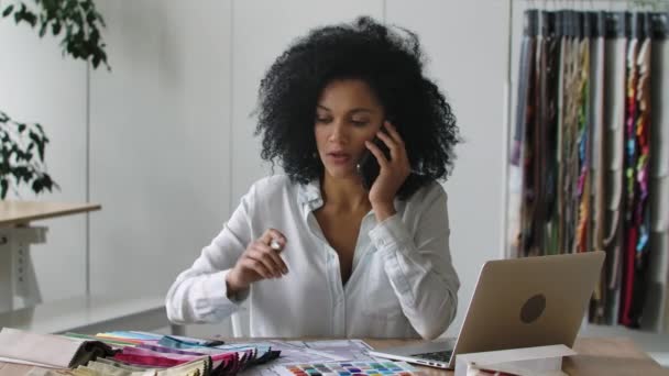 Portré fiatal afro-amerikai nő nézi át a színpaletta és minták szövetek és megvitatása design a projekt telefonon. Közelről. Lassú mozgás kész 59.97fps. — Stock videók