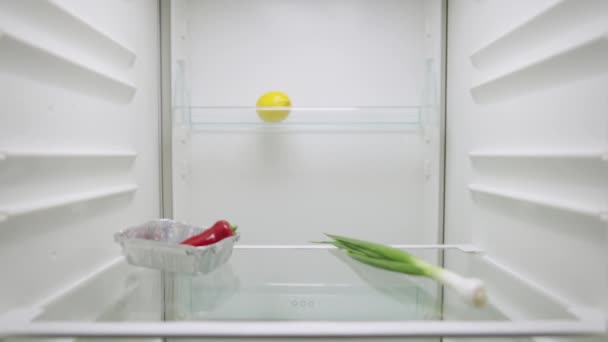 Entrega de compras en línea. Mujer abre nevera en busca de comida y utiliza moderno servicio de tienda de alimentos en línea para obtener la nutrición en casa. Vista desde el interior de la nevera. De cerca. Cámara lenta lista 59.94fps. — Vídeos de Stock