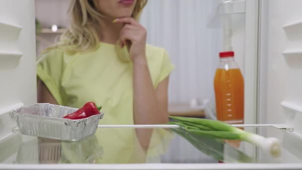 Hungrige Frau öffnet Kühlschrank Blick nach innen auf der Suche nach Nahrung und enttäuscht, aber das Problem kann gelöst werden. Online-Bestellung von Essenslieferungen. Blick aus dem Kühlschrank. Aus nächster Nähe. Zeitlupe bereit 59.94fps. — Stockvideo