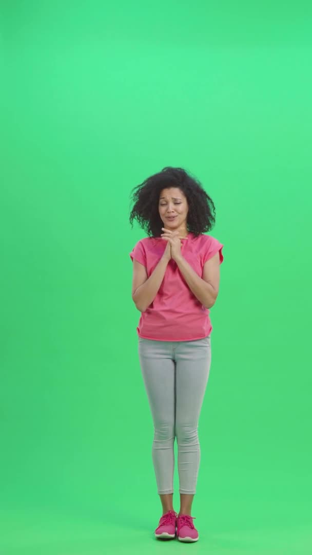 Portrait de jeunes Afro-Américaines gardant la paume de la main et demandant quelque chose. Femme noire aux cheveux bouclés pose sur écran vert. Prêt au ralenti 59,97 pi. Vidéo verticale. Longueur totale. — Video