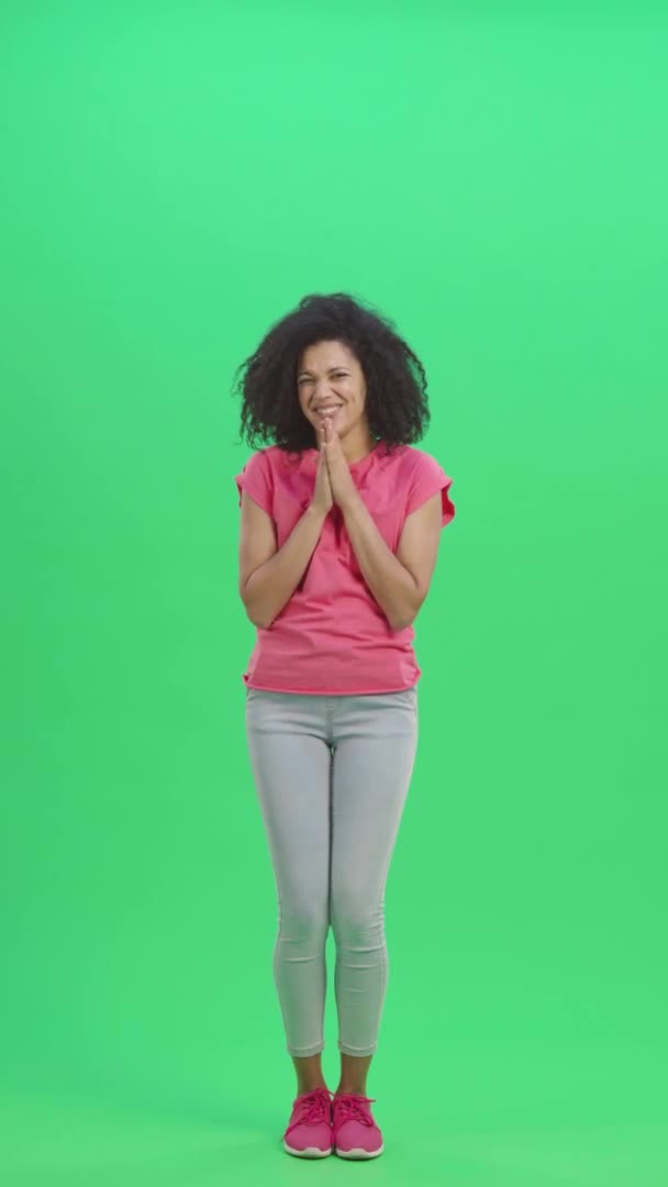 若い女性のアフリカ系アメリカ人の肖像画を一緒に手のひらを維持し、何かを求めている。緑色の画面に巻き毛のある黒人女性がポーズ。スローモーション準備ができて59.97fps。垂直ビデオ。全長. — ストック動画