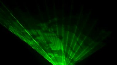 Dinamik yeşil lazer ışınları siyah stüdyo arka planında duman bulutları içinde dönüyor. Sahne hologramlarını göster. Tatiller ve partiler için ışıklandırma ekipmanı ve efektleri. Kapat..