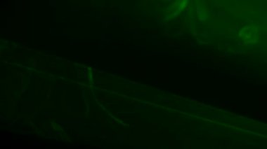 Parlak yeşil neon ışıklı ışıklar yanıp sönüyor ve dumanlı karanlık bir stüdyoda ışık saçıyor. Sahne ışıkları. Aydınlatma, aydınlatma, sahnede tiyatro dumanı. Tatil, gece kulübü, disko, parti. Kapat..