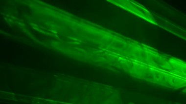 Parlak yeşil neon ışıklı ışıklar yanıp sönüyor ve dumanlı karanlık bir stüdyoda ışık saçıyor. Sahne ışıkları. Aydınlatma, aydınlatma, sahnede tiyatro dumanı. Tatil, gece kulübü, disko, parti. Kapat..