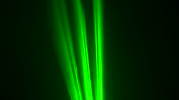 Färgglada gröna neon laserljus på svart studio bakgrund snurrar i puffar av rök. Laserhologram svänger och avger ljusstrålar. Ljuseffekter för design, scenbelysning, show, disco. Närbild. — Stockvideo