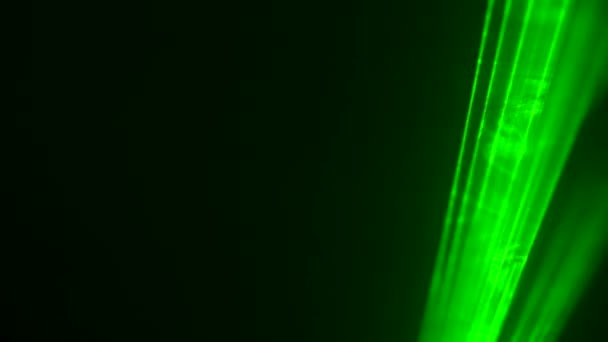 Барвисті зелені неонові лазерні ліхтарі на чорному студійному фоні, що обертаються в пуфиках диму. Лазерні голограми обертаються і випромінюють світлові промені. Світлові ефекти для дизайну, сценічне освітлення, шоу, диско. крупним планом . — стокове відео