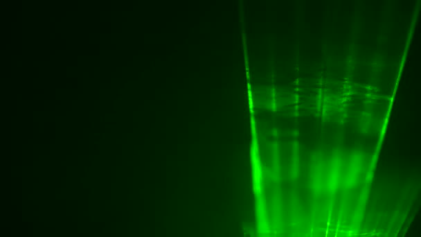 Ljus grön neon laserljus blinkar under konserten på svart rökig bakgrund scenen. Laserljus rör sig i rökpuffar. Professionell färg belysning och ljus visa effekter för fest. Närbild. — Stockvideo