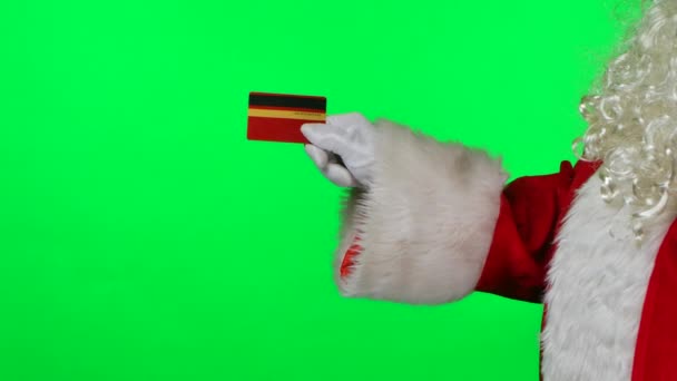 Vista lateral Santa Claus con una barba en guantes blancos tiene una tarjeta de crédito en sus manos. Aislado en una pantalla verde en el estudio. Clave de croma. De cerca. Movimiento lento. — Vídeos de Stock